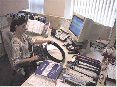 Goodyear Customer Service Specialist holds new WhiteHawk Pd - BlackHawk Pd belt while processing a customer order. One of the many features includes a parts numbering system, compatible with industry numbers for ease of ordering.
